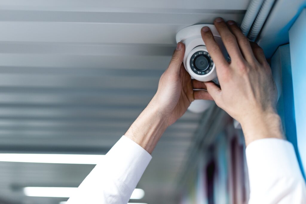 partial view of man setting up security camera